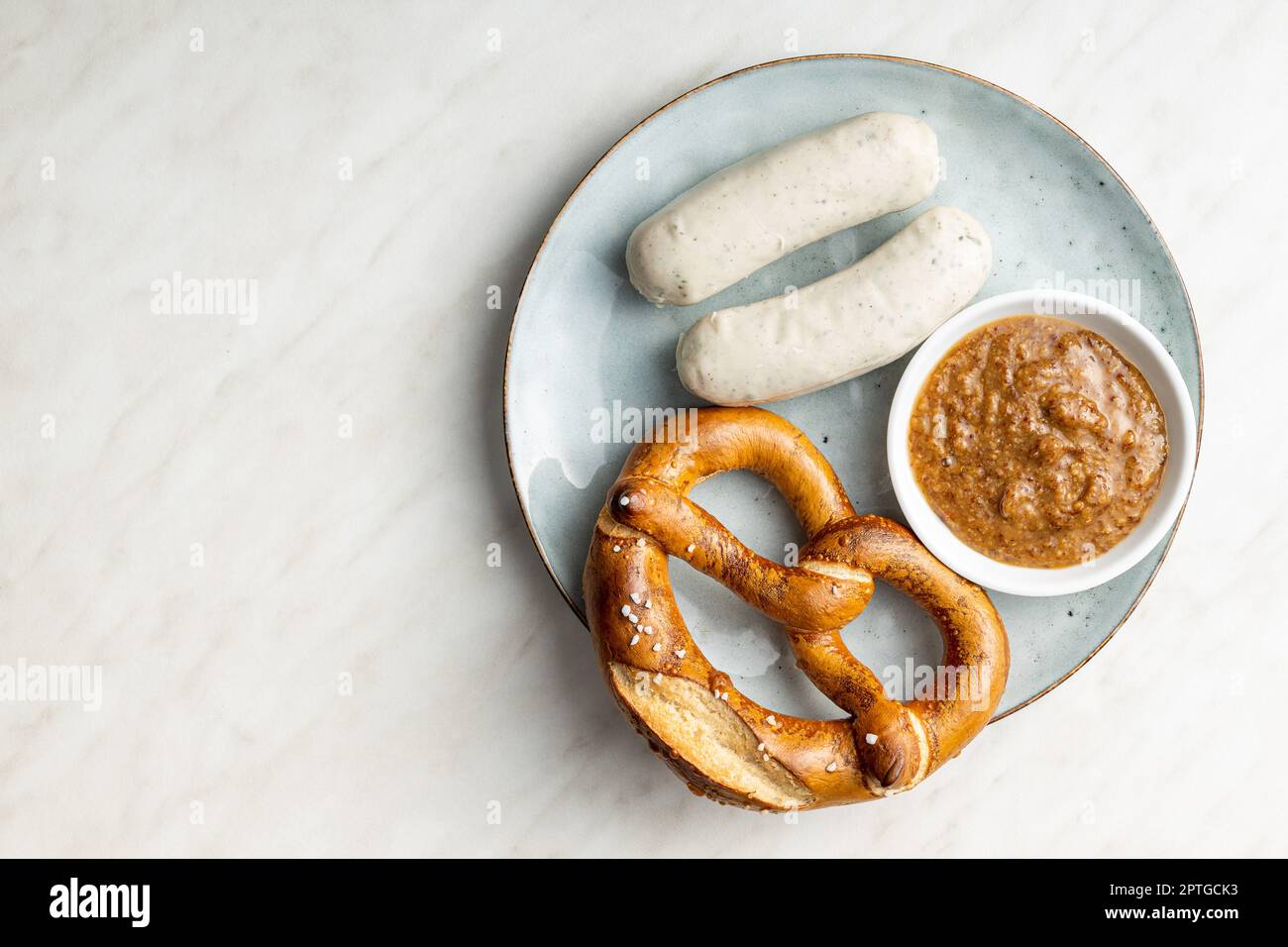 Traditional Bavarian white sausages on the plate and pretzes. Top view. Stock Photo