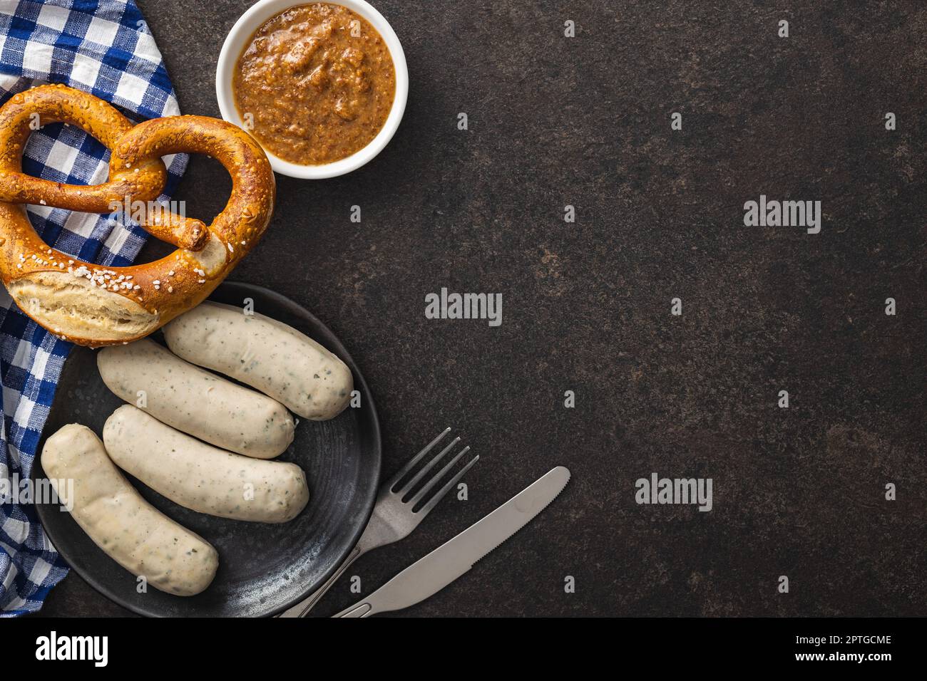 Traditional Bavarian white sausages on the plate and pretzes. Top view. Stock Photo