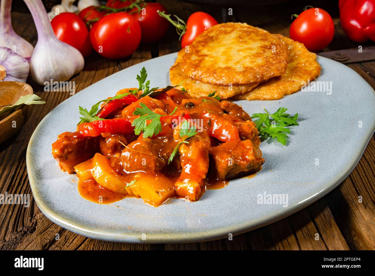Spicy pork stew with potato pancakes Stock Photo