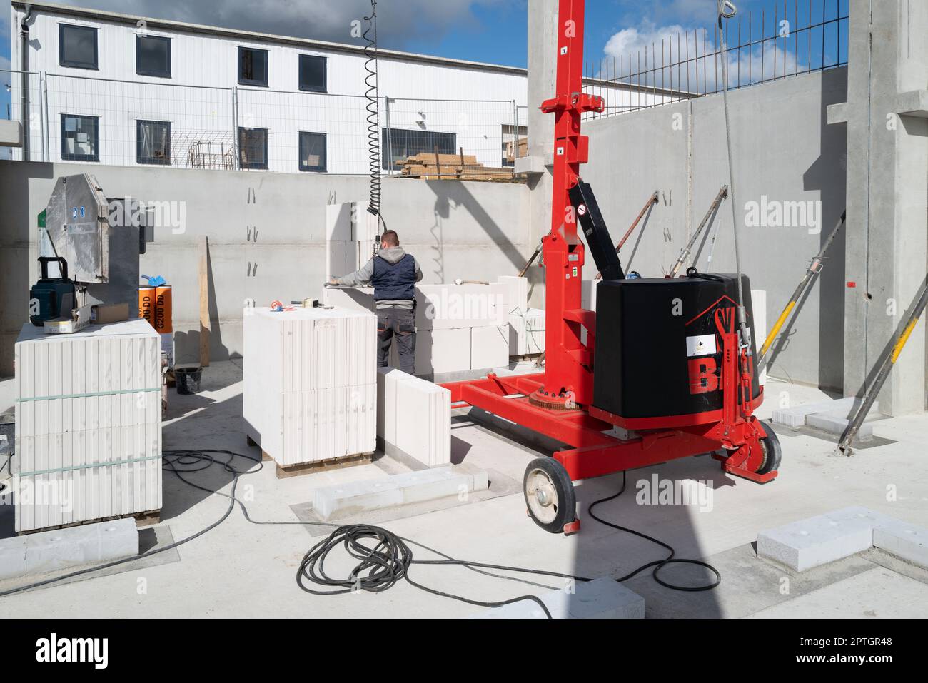 bricklayer erects a concrete wall on a construction site Stock Photo
