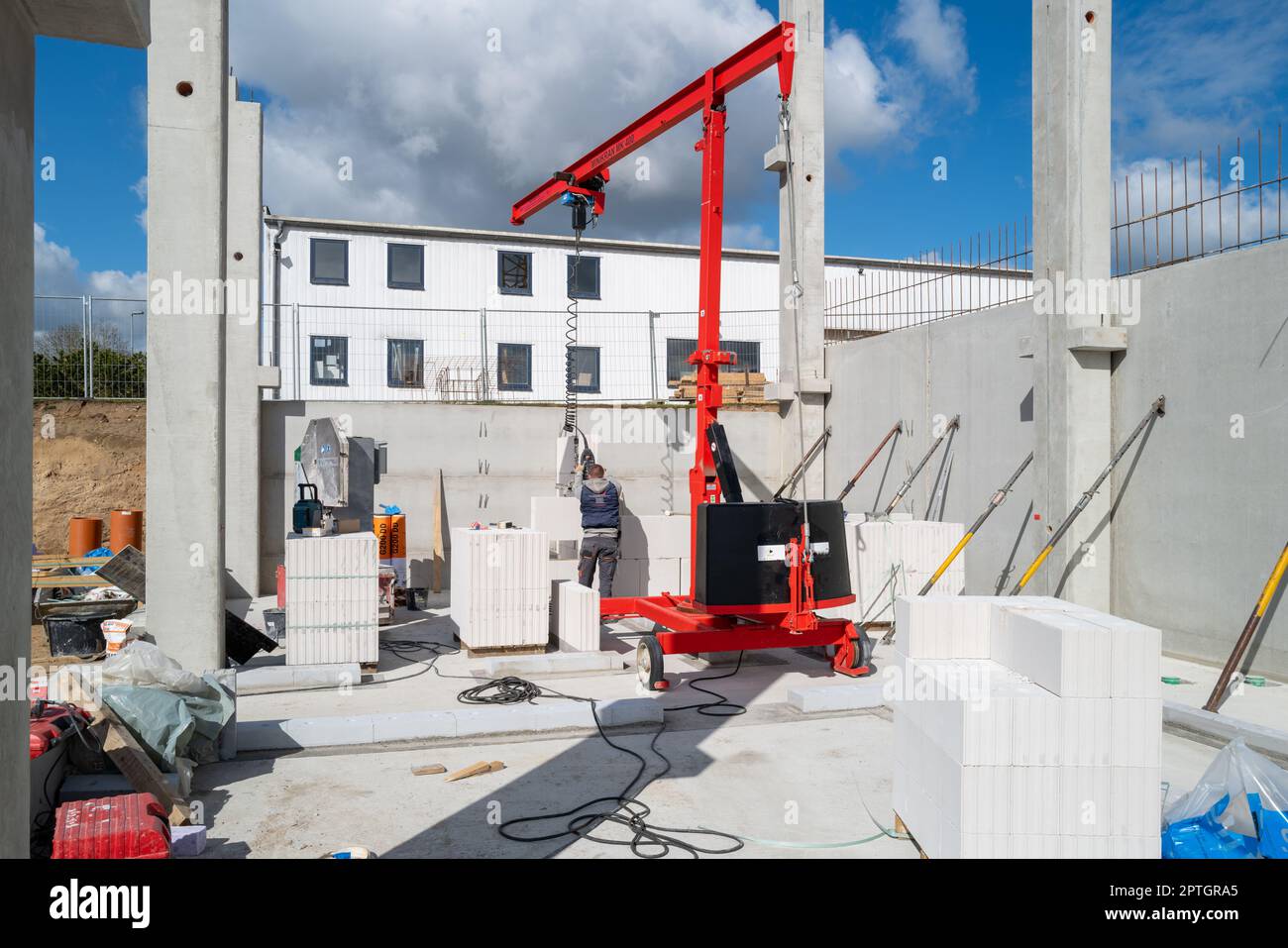 bricklayer erects a concrete wall on a construction site Stock Photo