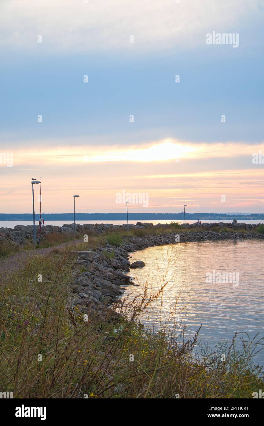Sunset in Sweden at the harbor of lake Vaettern. Lighthouse in the ...