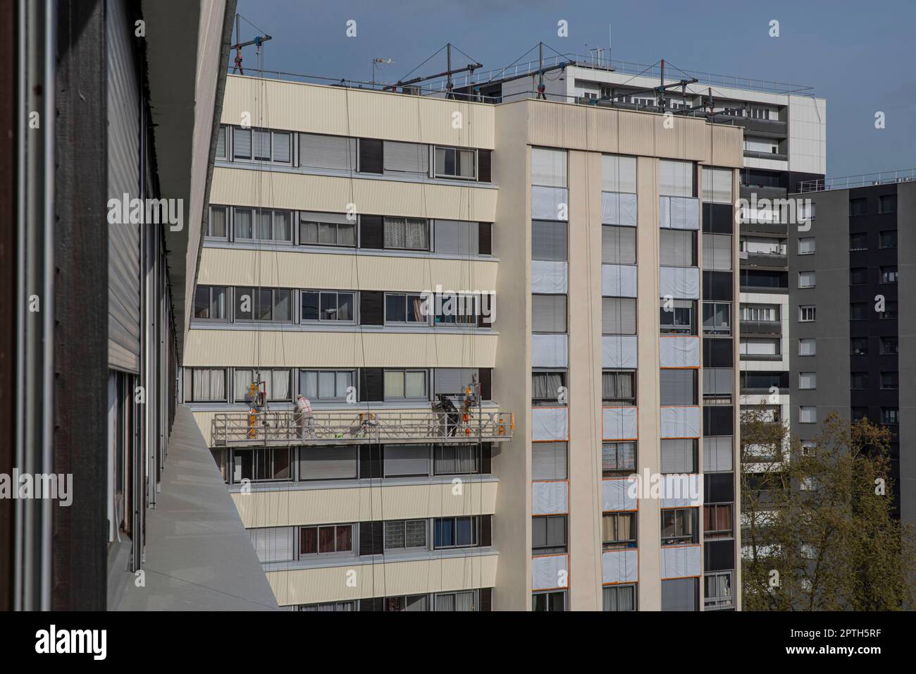 Workers on a scaffold are doing the renovation of a building Stock Photo