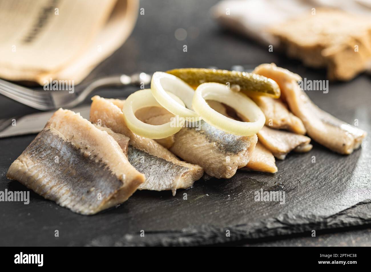 Marinated herring fish on the kitchen table. Stock Photo