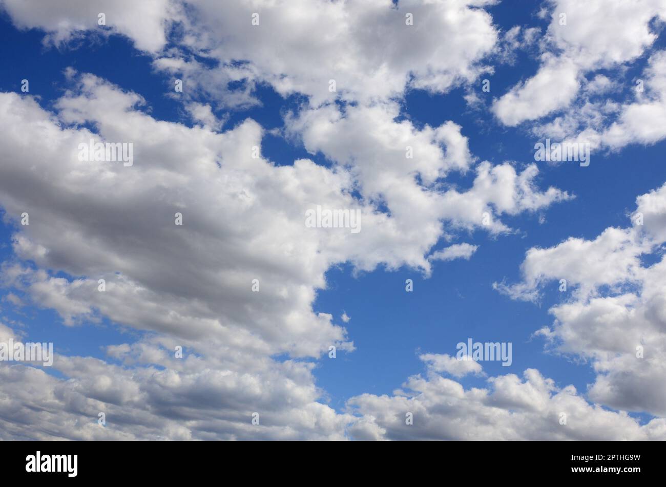 A blue sky with lots of white clouds of different sizes Stock Photo - Alamy