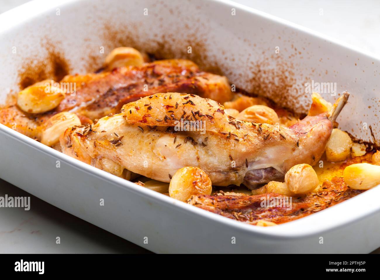 baked rabbit leg with garlic and bacon Stock Photo Alamy
