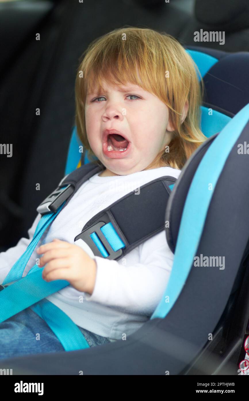 Sad, crying and portrait of baby in car seat for fear, and travel safety. Security