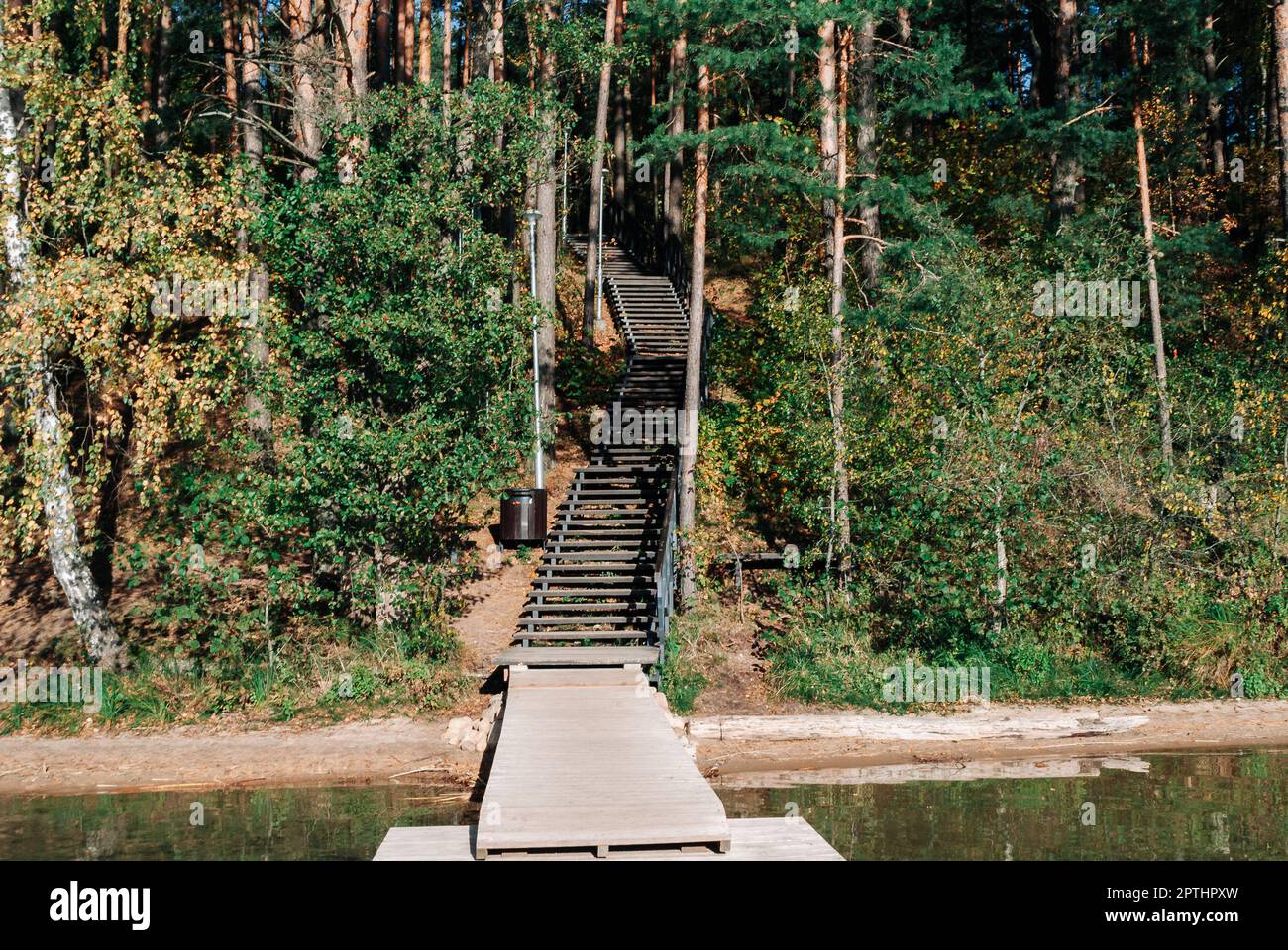 Wooden staircase descending to a wooden pier on Lake Baltieji Lakajai in Labanoras Regional Park, Lithuania. Stock Photo