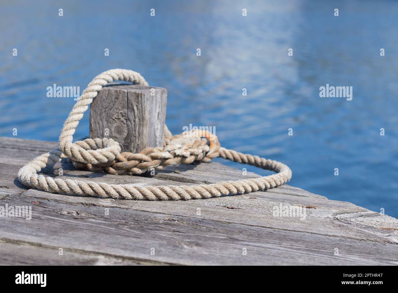 A mooring line around a bollard on a wooden pier Stock Photo - Alamy
