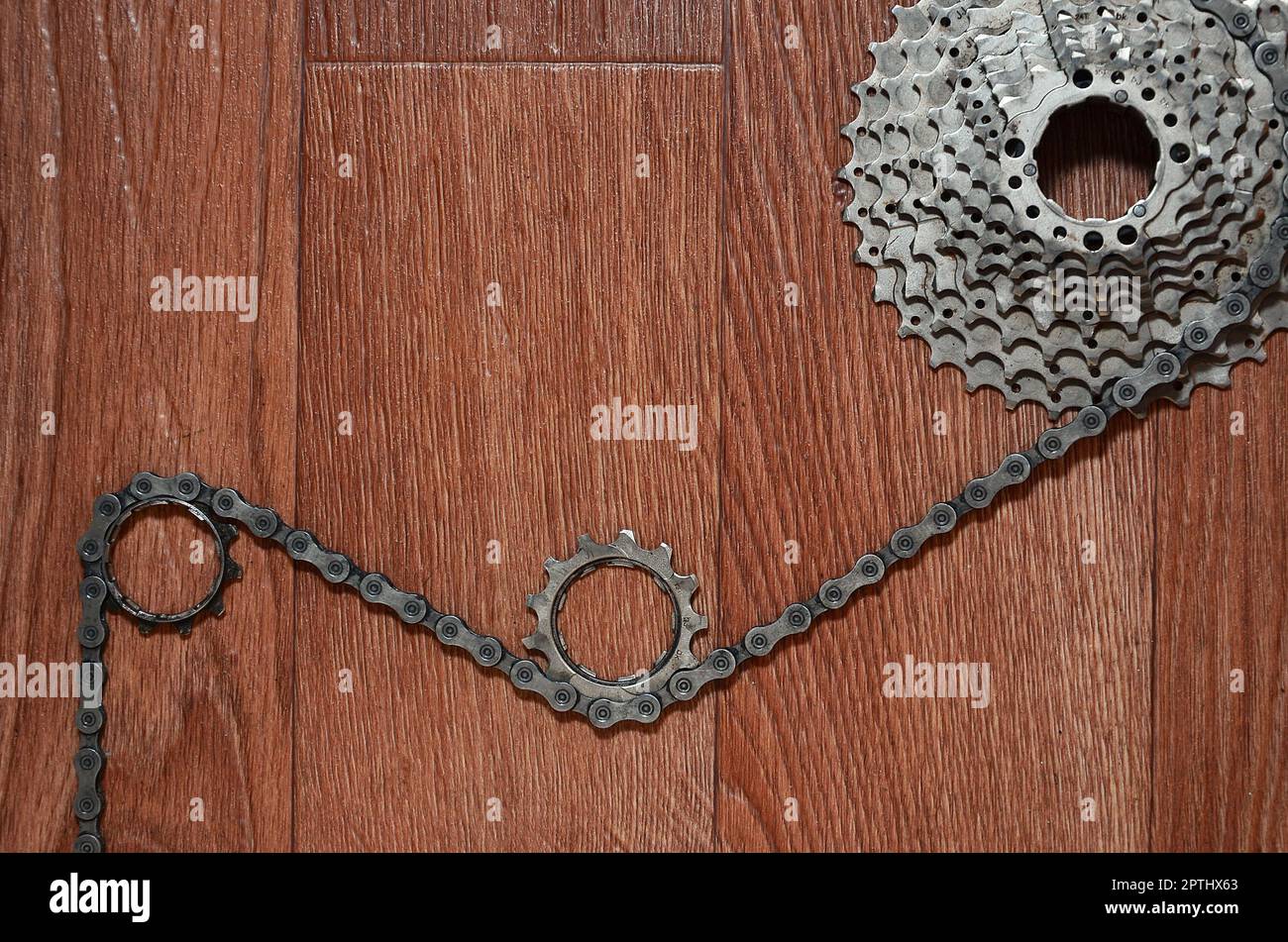 Some composition of a bicycle chain, several sprockets and other components of a sports bike