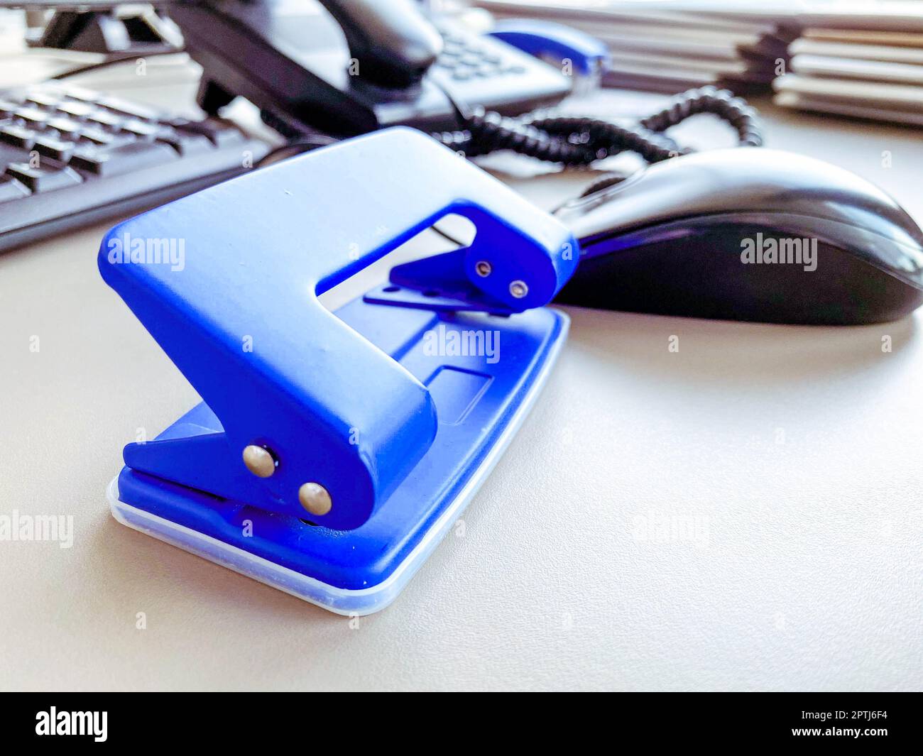 office supplies for work. a blue hole punch lies on the table for making holes in documents