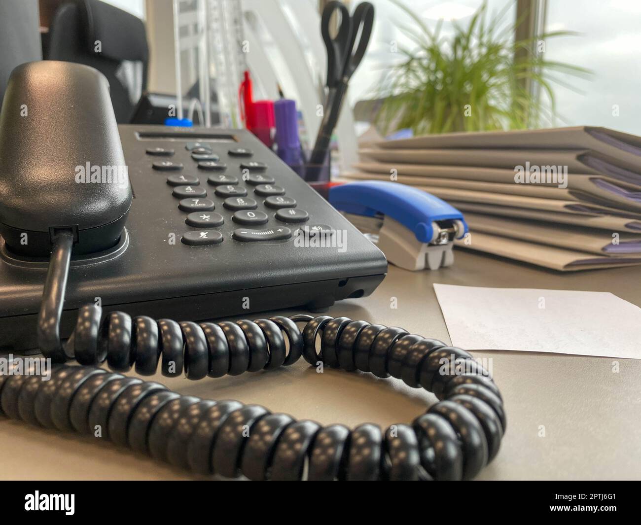 Gray and black business wired phone with receiver, dial and large