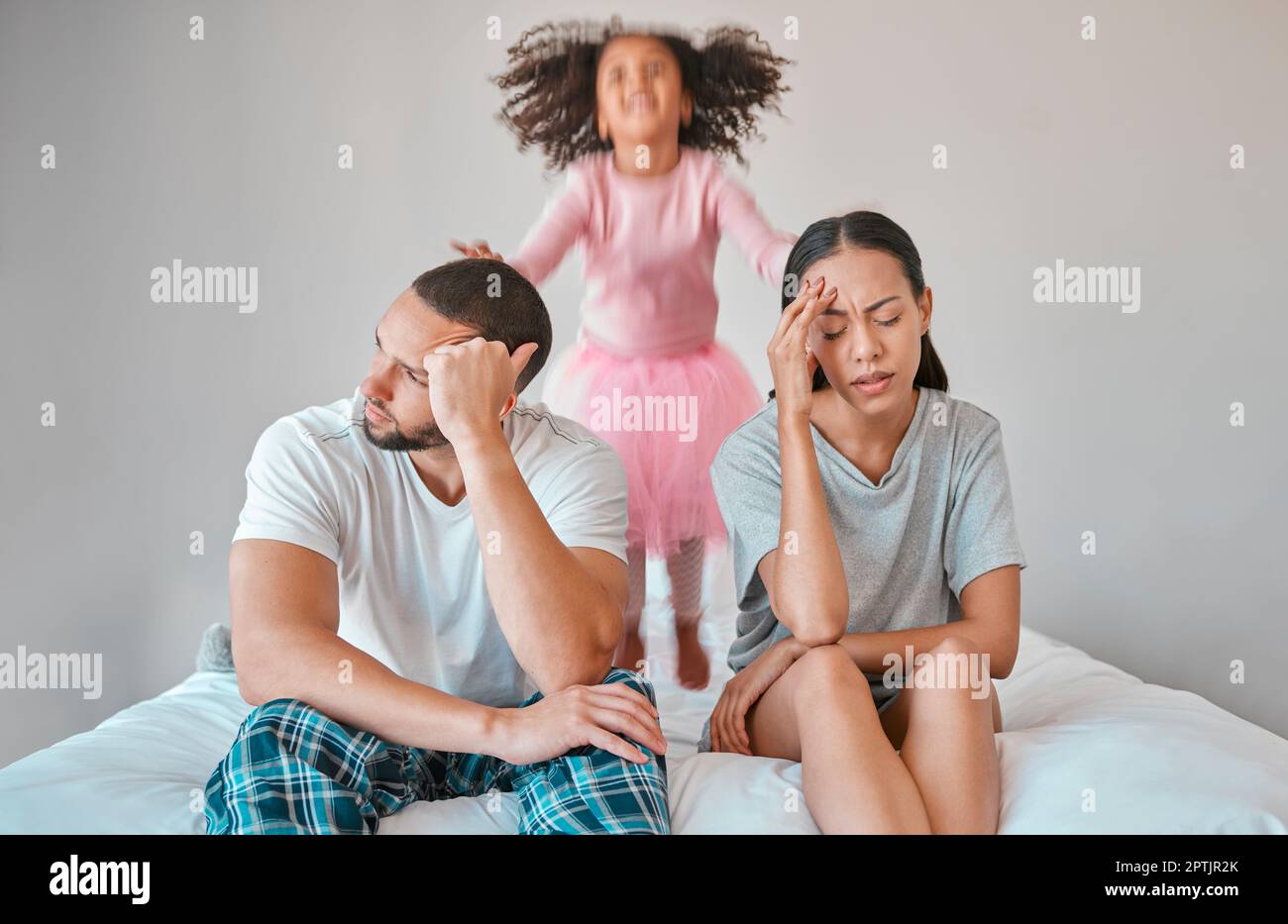 Stress, divorce and couple with a child on the bed with her parents in an argument or disagreement. Tired, break up and young angry mother and father Stock Photo