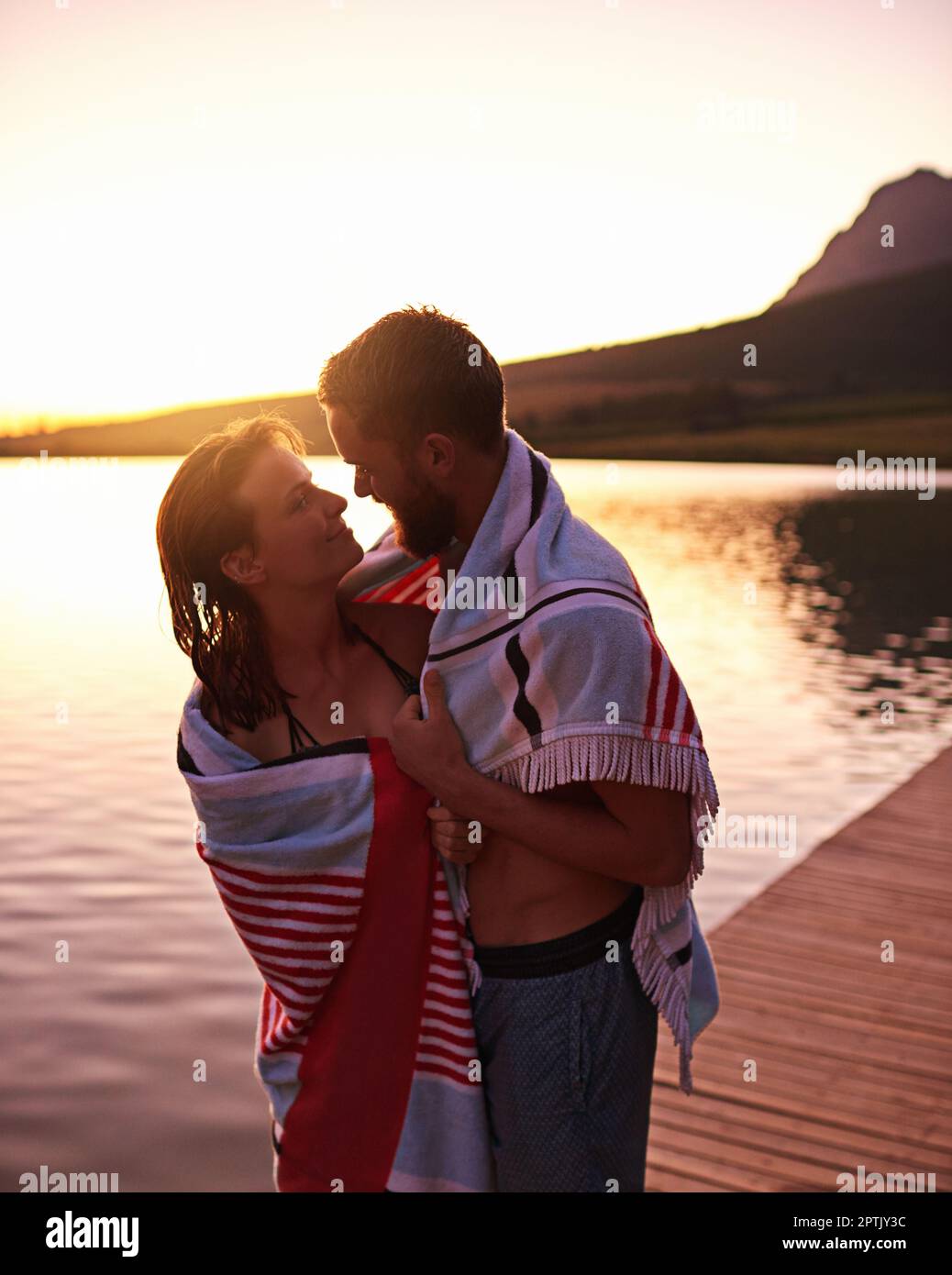 Lakeside love. an affectionate young couple in swimsuits wrapped in a