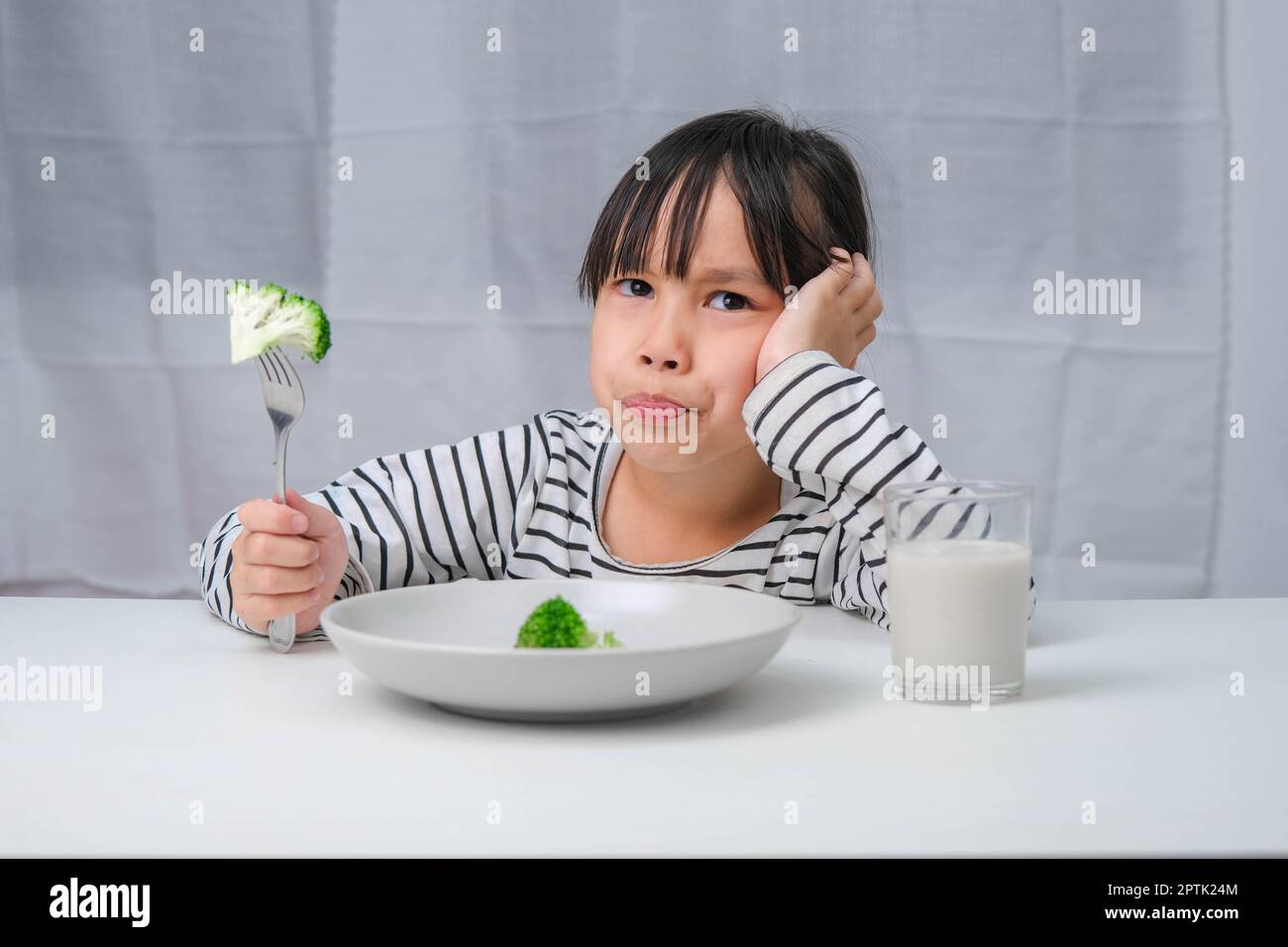 Children don't like to eat vegetables. Cute Asian girl refusing to eat ...