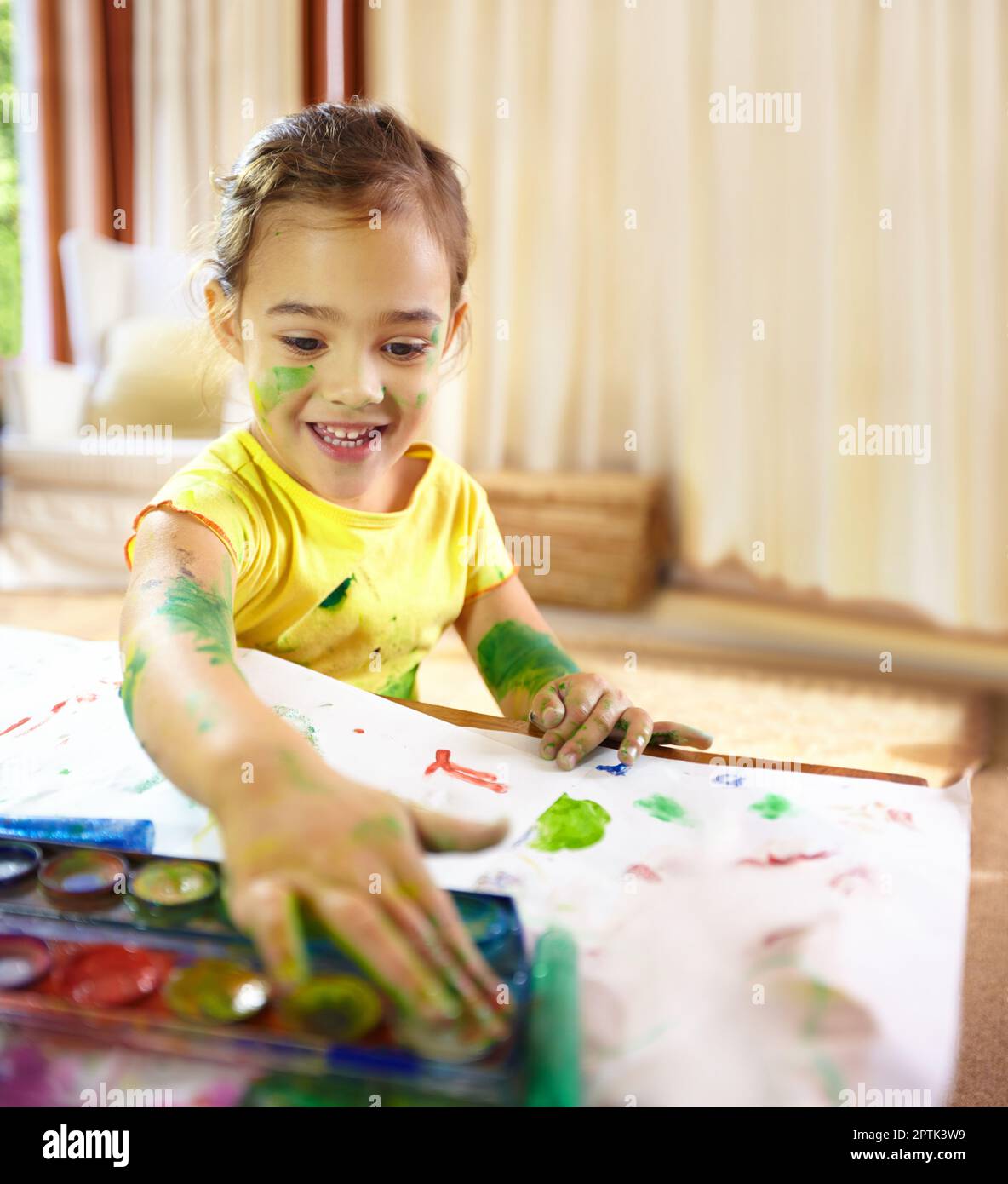 Finger painting fun. an adorable little girl making a mess while