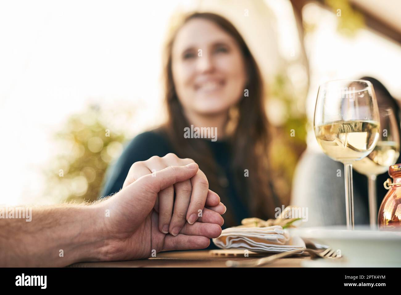 Couple, dinner and holding hands to celebrate love, support and marriage together outdoor. Romance date, woman and lunch with man for quality time, ha Stock Photo