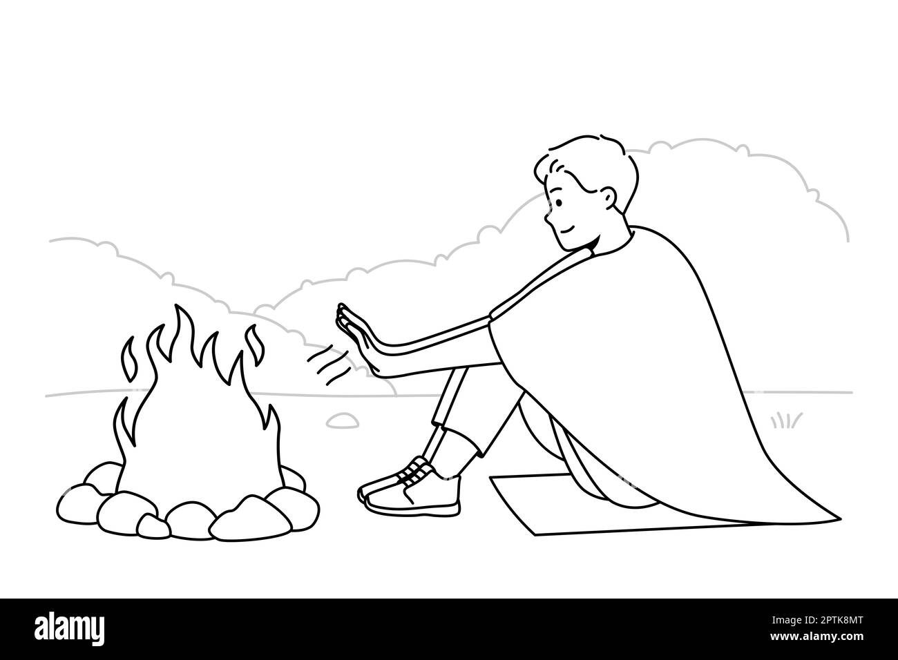 Young man sit on ground in nature warm hands at campfire at night