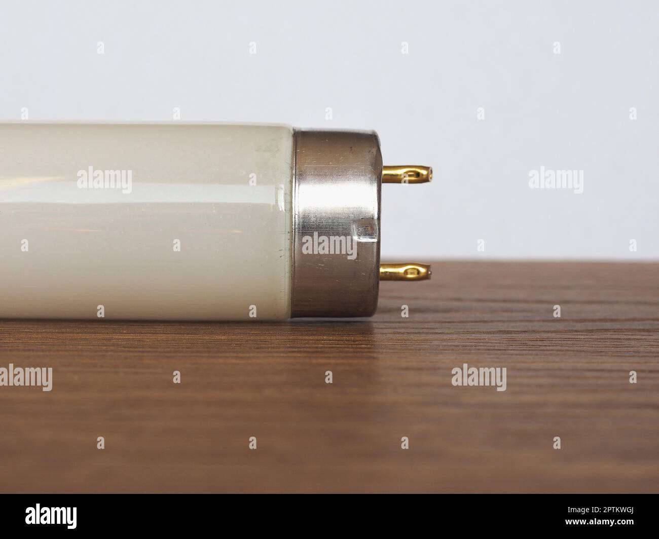 fluorescent tube light bulb over wooden desktop Stock Photo Alamy