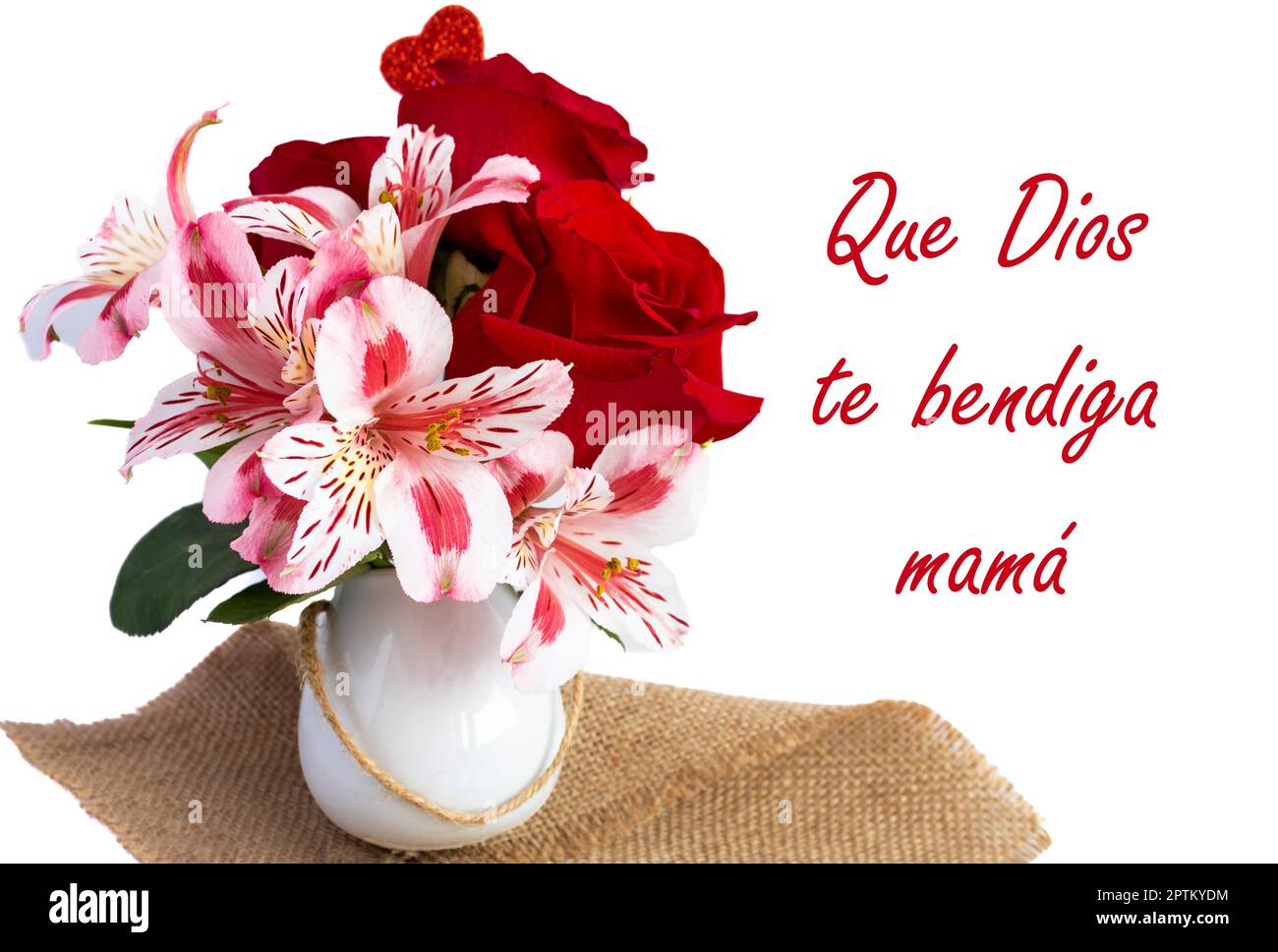close up of small white vase with red roses and pink flowers on a white