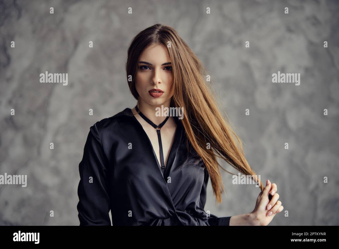 Beautiful woman touching her long hair Stock Photo - Alamy
