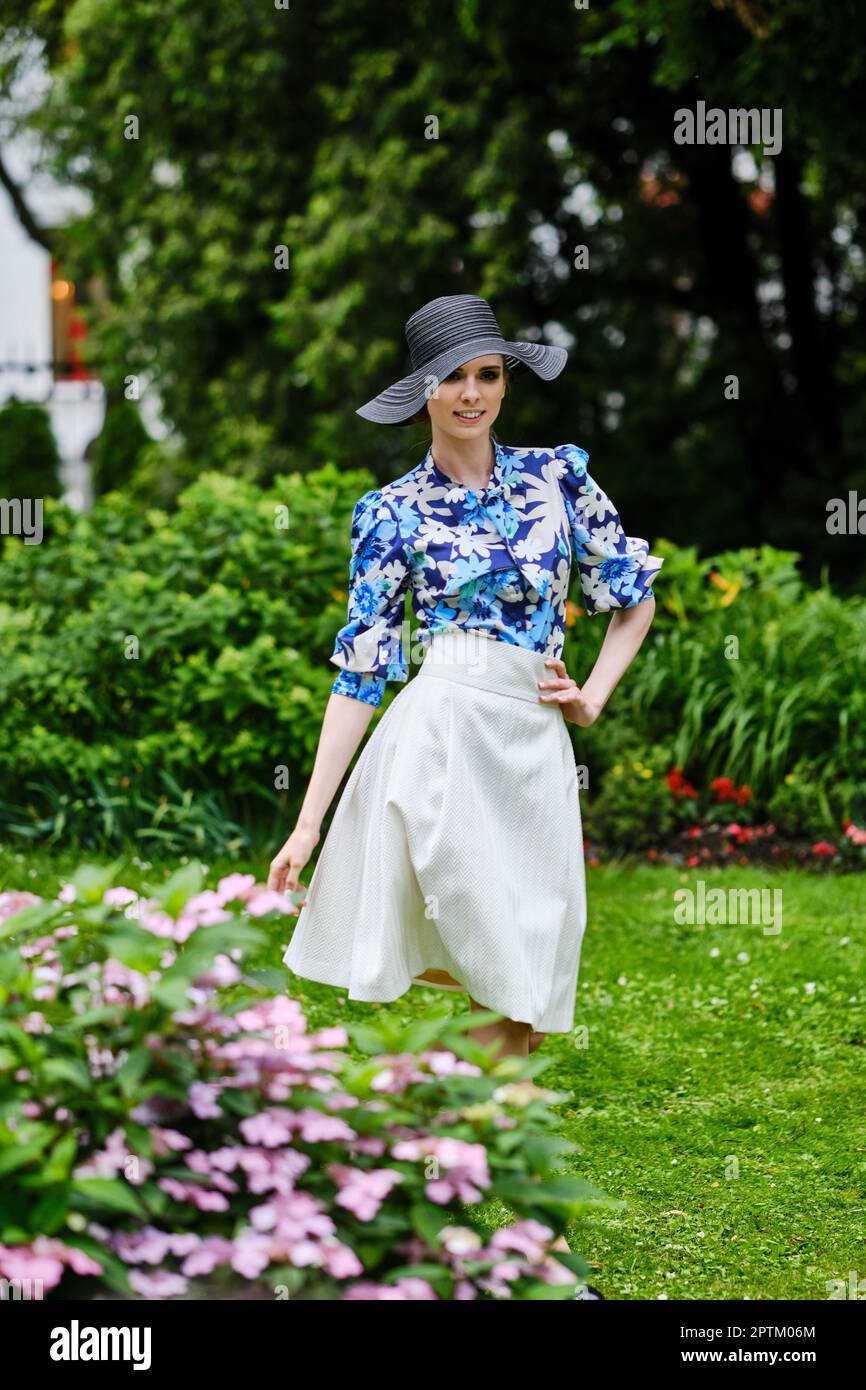 Portrait of smiling girl in black broad brim hat, blue blouse and