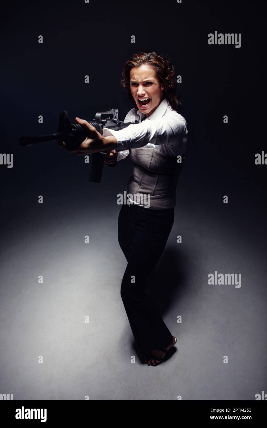 In the mood to shoot. Full length shot of an aggressive woman standing ...