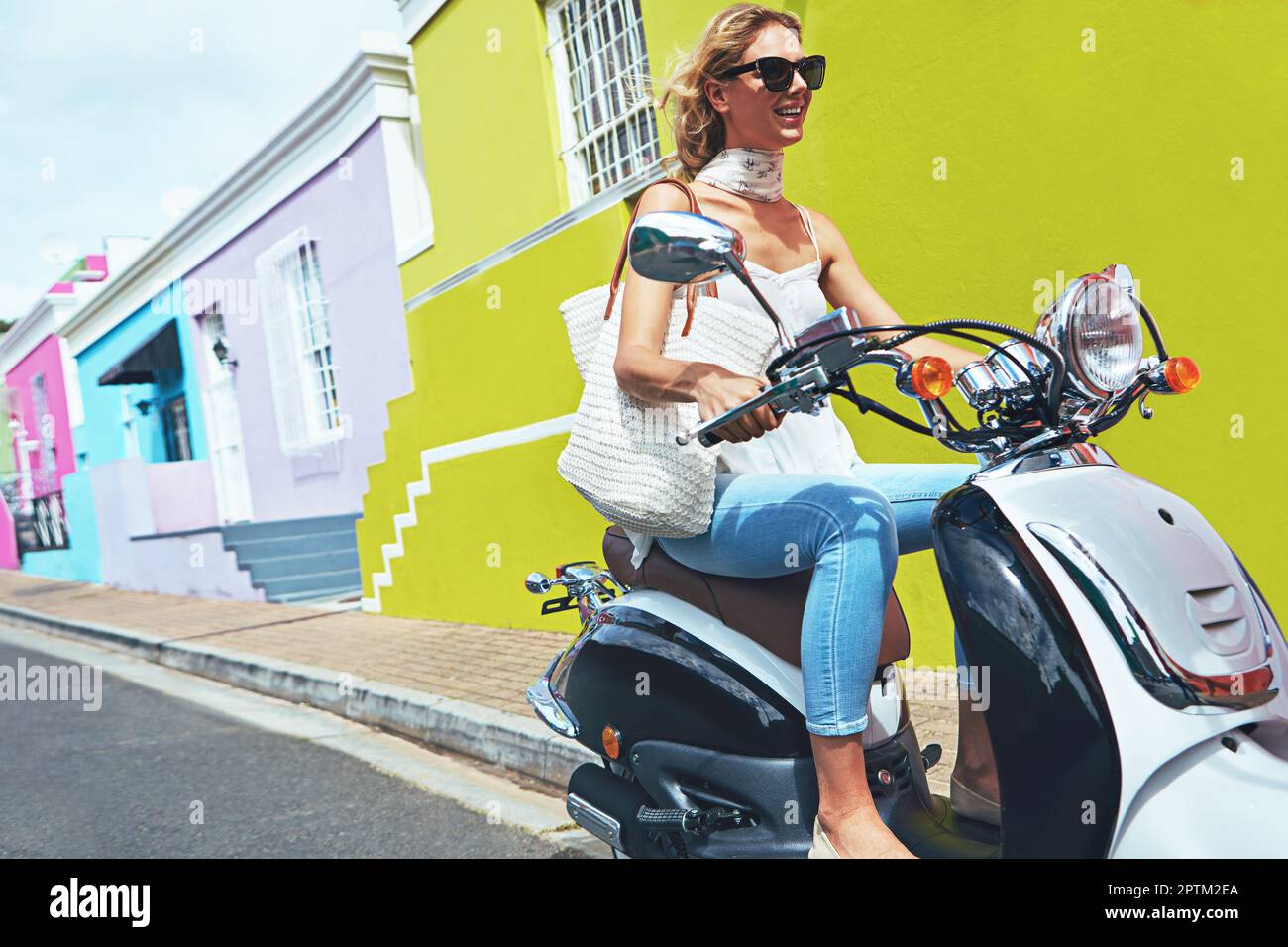 Happy smiling and screaming male tourist in helmet and sunglasses riding motorbike  scooter during his tropical vacation under palm trees Stock Photo - Alamy