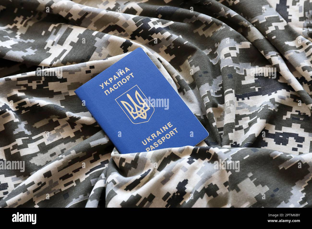 Ukrainian foreign passport on fabric with texture of military pixeled
