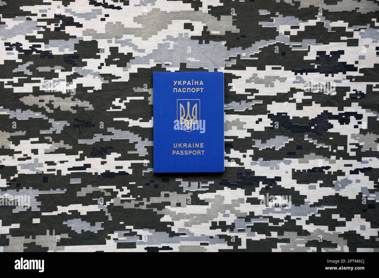 Ukrainian foreign passport on fabric with texture of military pixeled