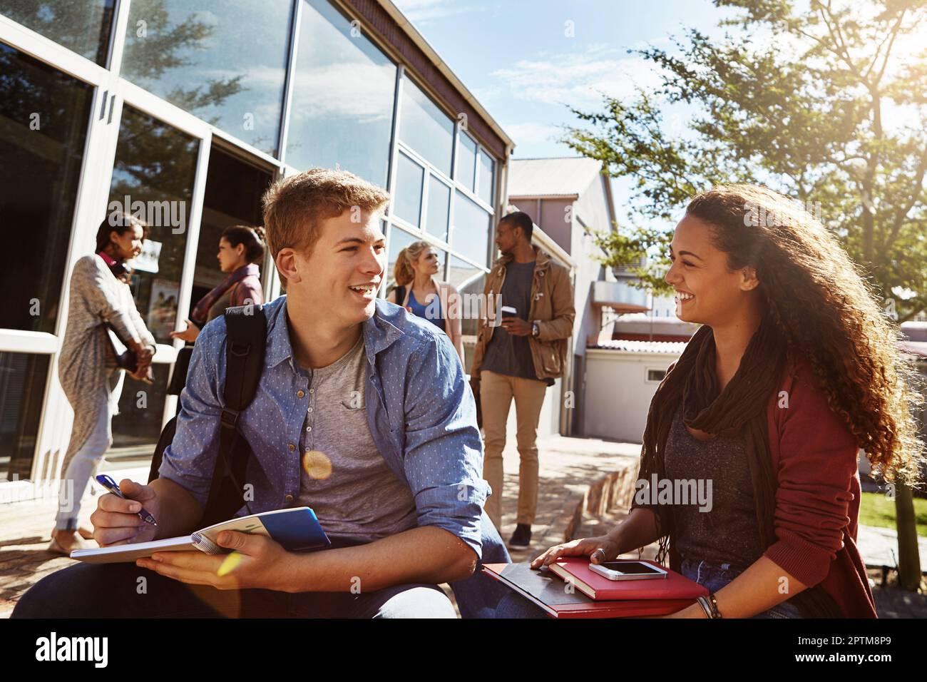 We should study together more often. two students studying together on campus. Stock Photo
