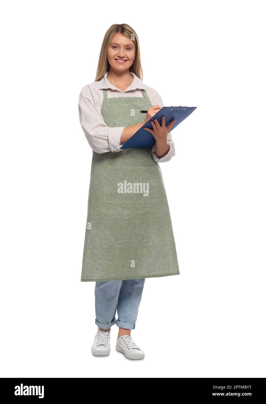 Beautiful young woman in clean apron with clipboard on white background ...