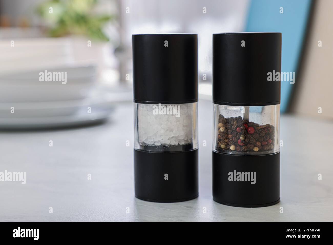 https://c8.alamy.com/comp/2PTMFW8/salt-and-pepper-shakers-on-white-table-space-for-text-2PTMFW8.jpg