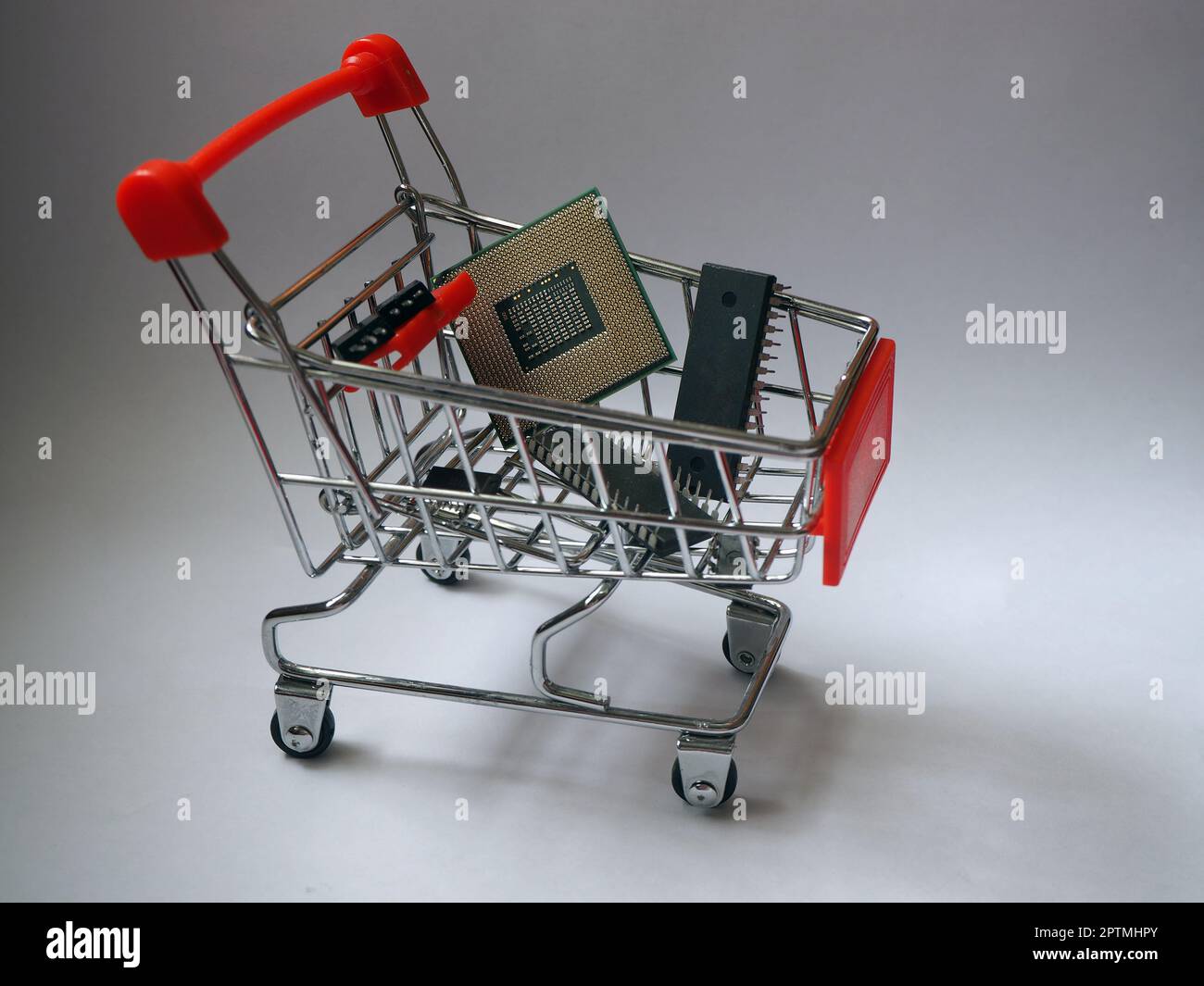 Shopping cart with chips, CPU and integrated circuits. Semiconductor manufacturer and supply chain. Chip market and trading concept. Stock Photo
