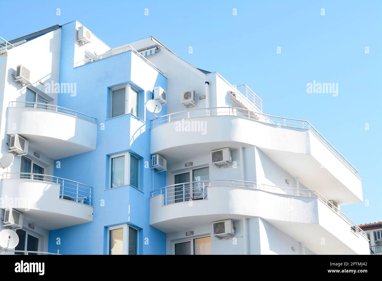 Modern building with large comfortable balconies against light blue sky ...