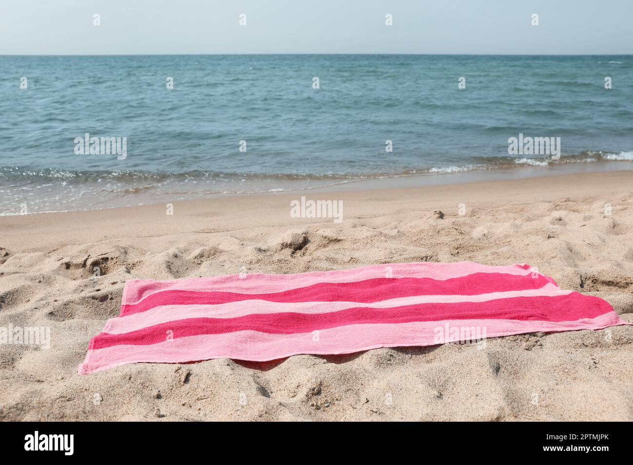 Pink striped towel on beach sand near sea Stock Photo - Alamy