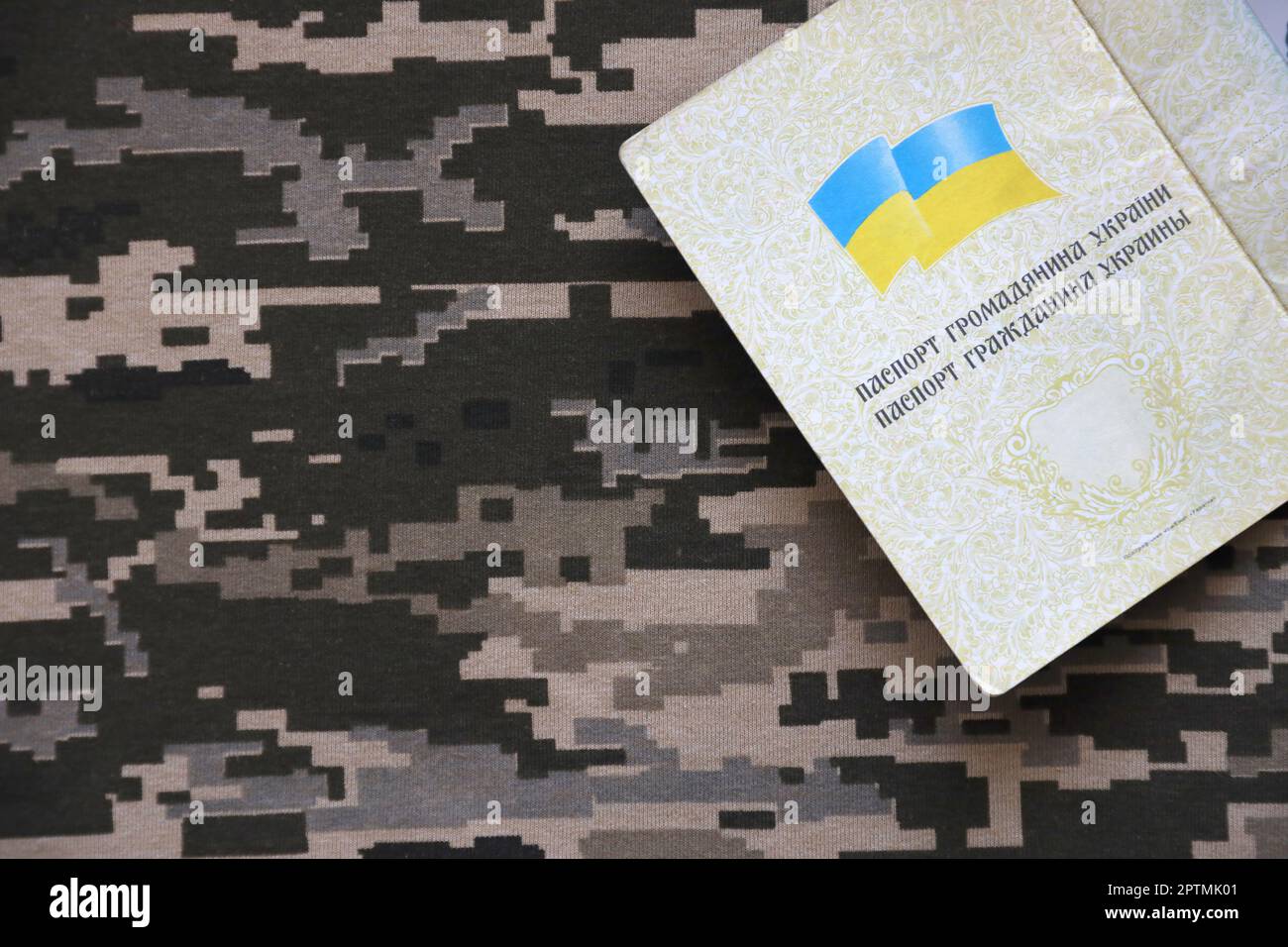 Ukrainian foreign passport on fabric with texture of military pixeled