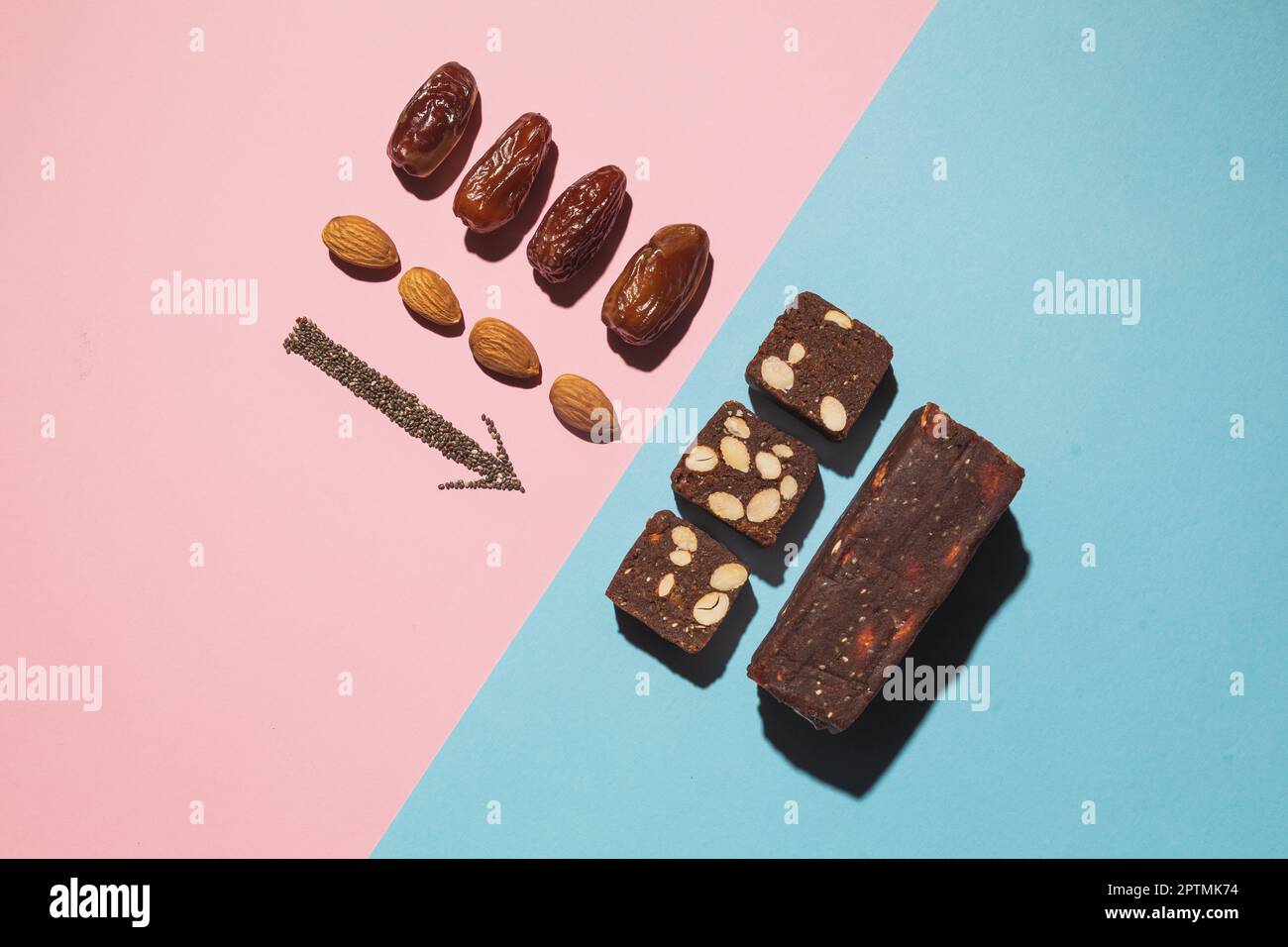 Protein date fruit candy bars fitness with nuts fruit and almond and chia and poppy seeds, top view on blue pink background with copy space and place Stock Photo