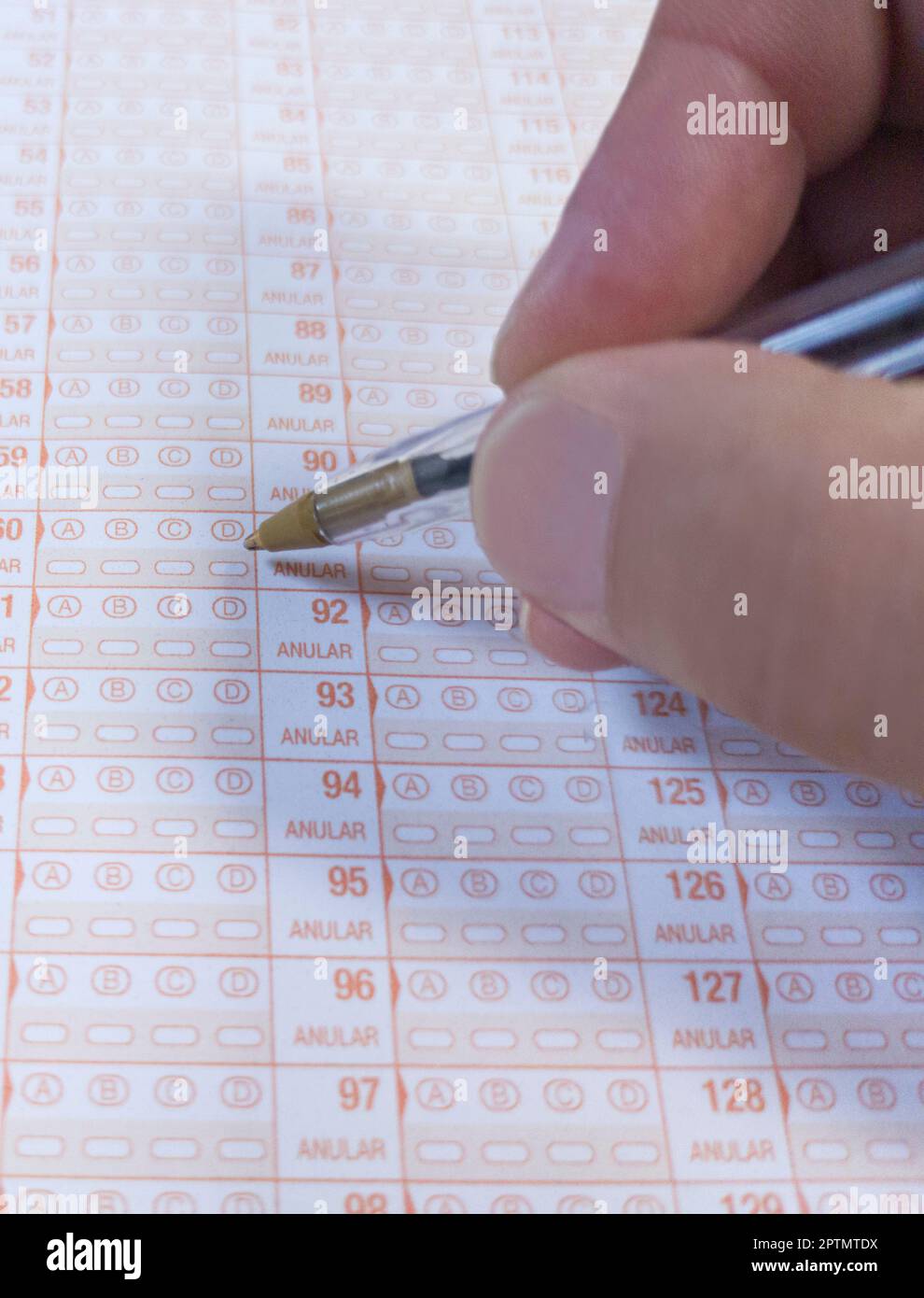 Candidate hand holds a ballpen over multiple-choice test. Public examination concept Stock Photo