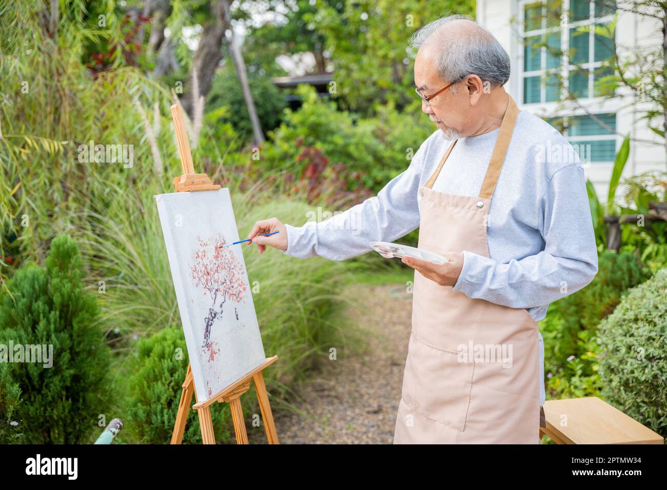 Lifestyle artist. Senior old man painting picture artwork using brush