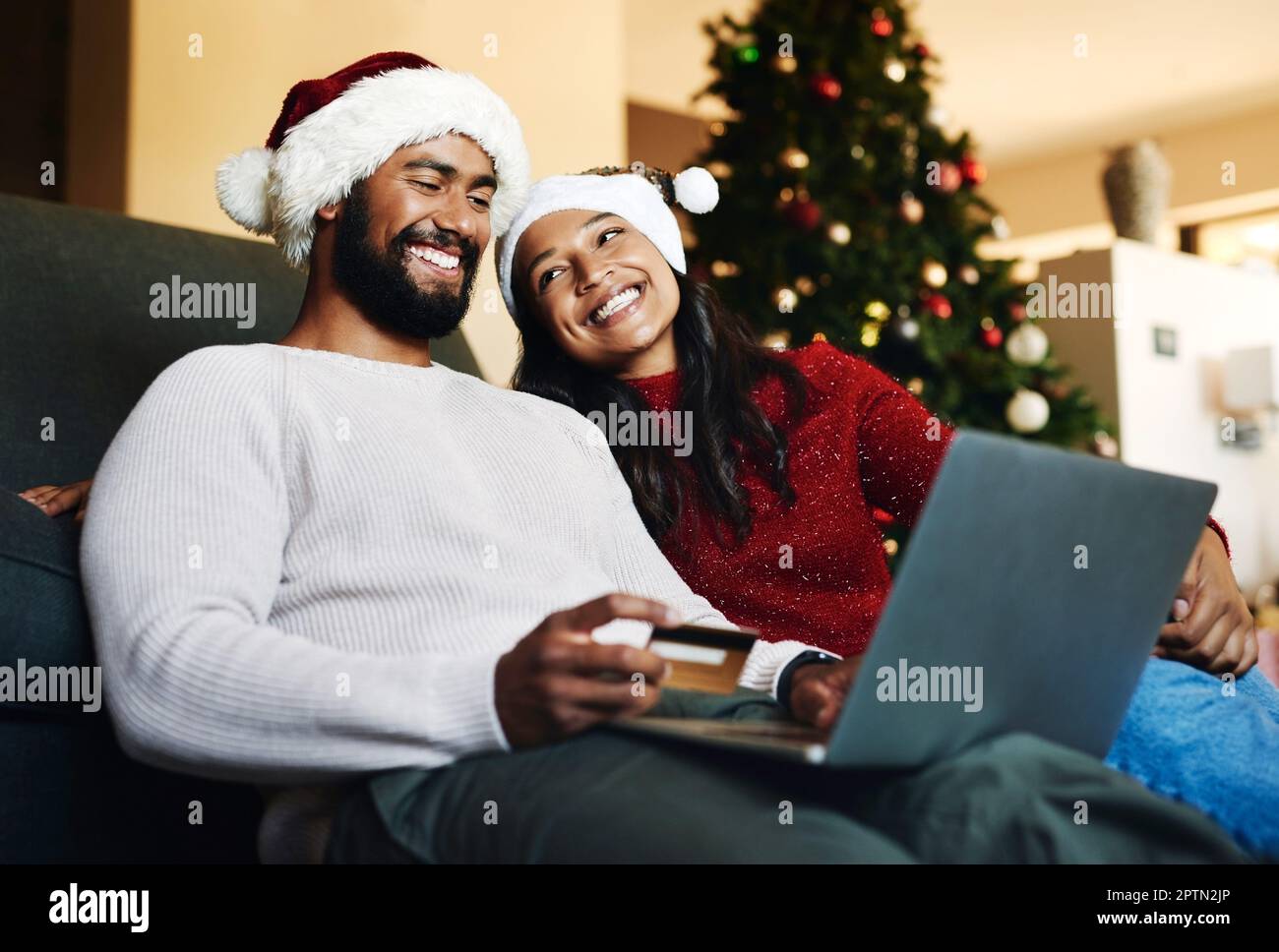 Christmas, couple and couch with laptop, credit card and together for