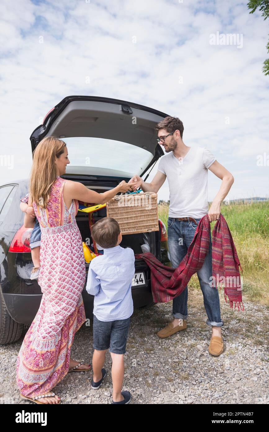 Family unloading the car on meadow in the countryside, Bavaria, Germany Stock Photo