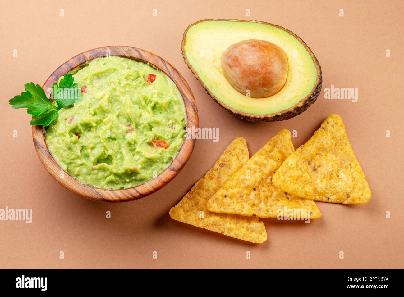 Guacamole bowl avocado and chips isolated on table. Flat lay. Stock Photo