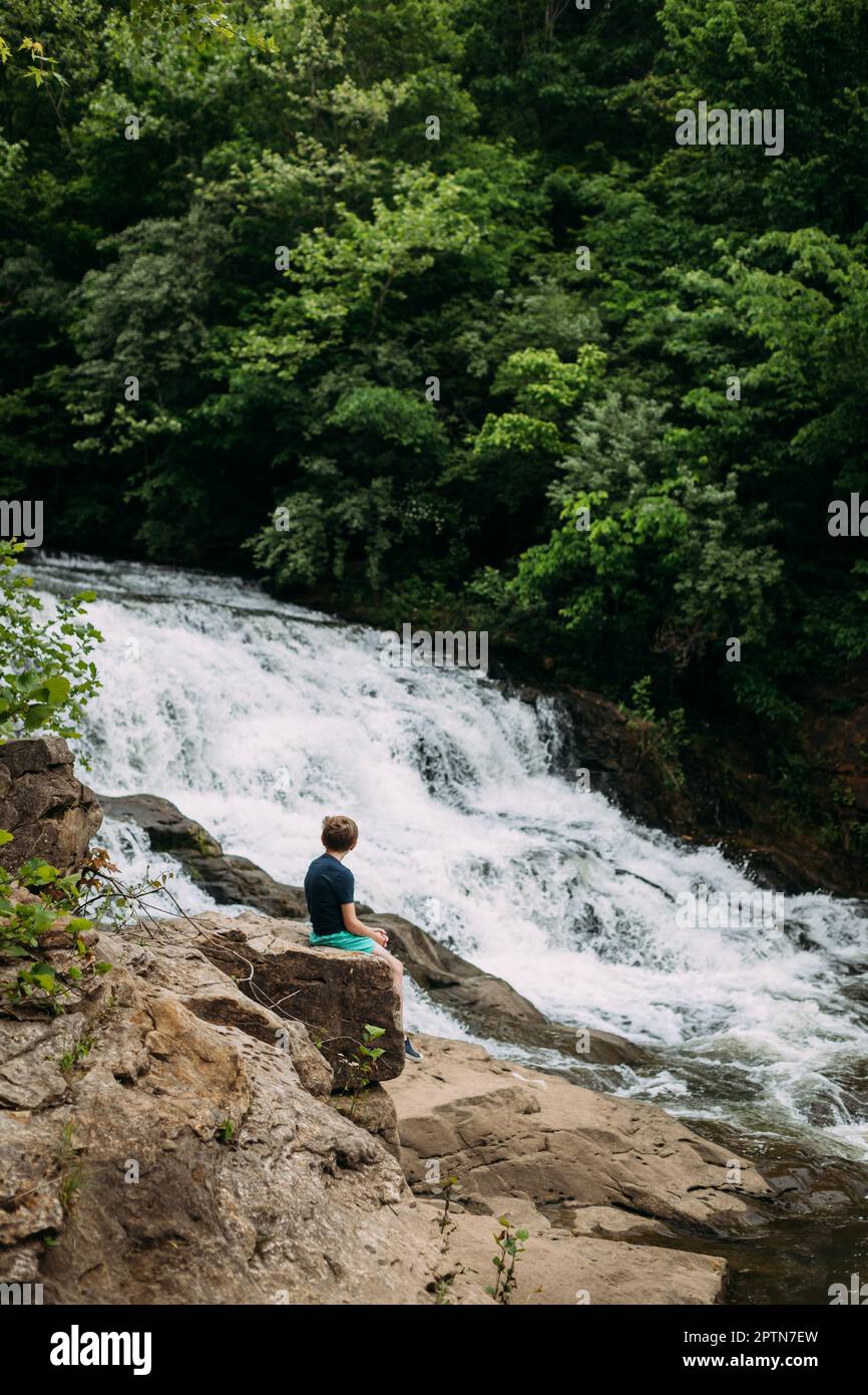 Person sitting on rocks hi-res stock photography and images - Alamy