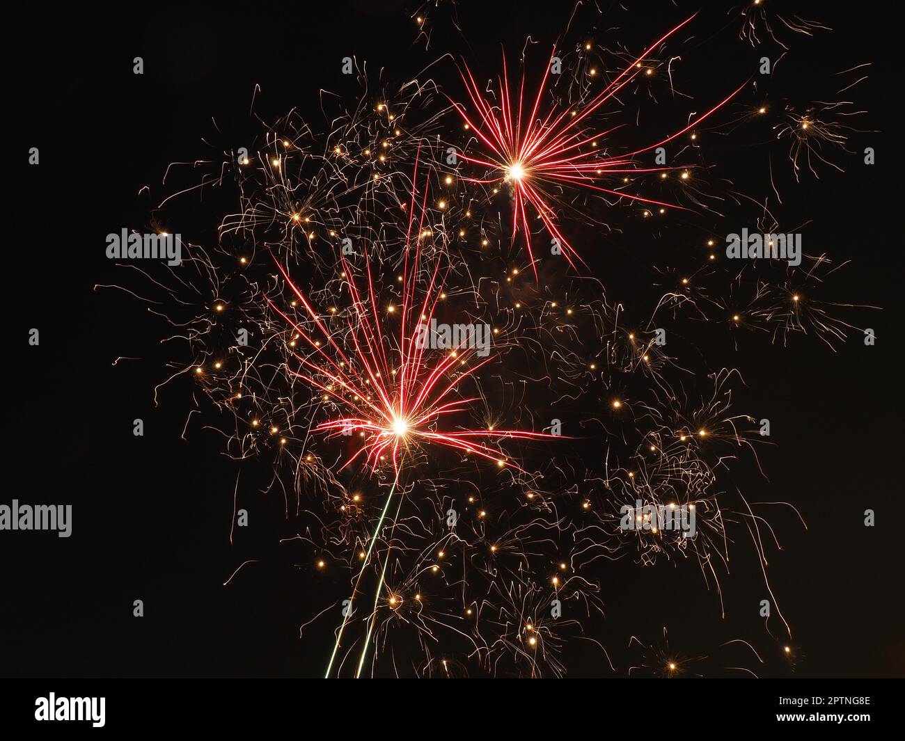 fireworks in the night sky. Colorful flashes of fire on black background. Celebration, festival or victory symbol. Explosions of fire and sparks in th Stock Photo