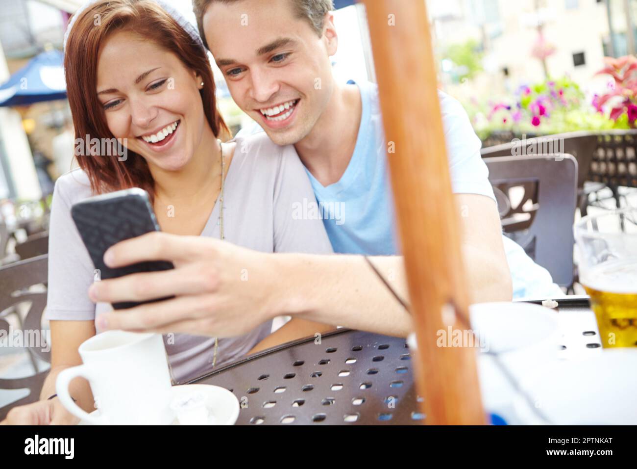 Look at this one. A happy couple laughing at something on a cellphone while  having coffee at a cafe Stock Photo - Alamy