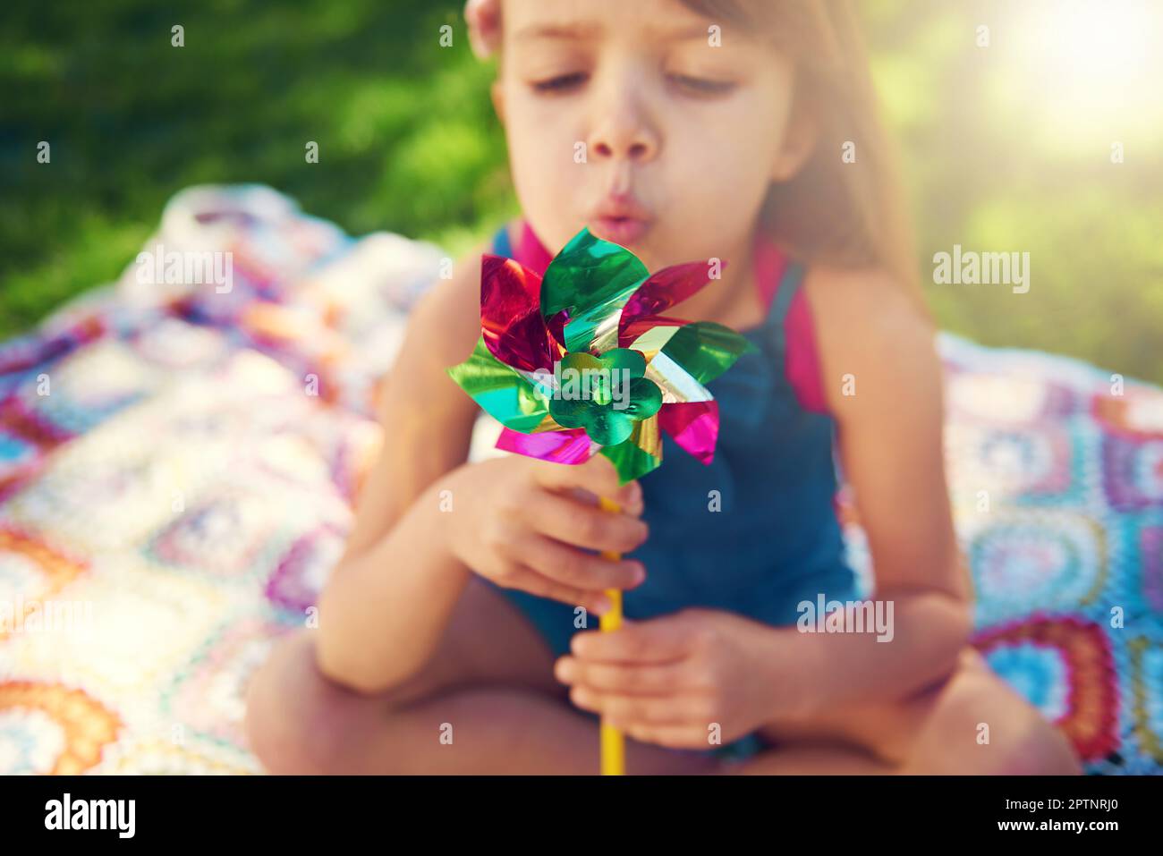 Only children believe theyre capable of everything. a little girl having fun on the lawn Stock Photo