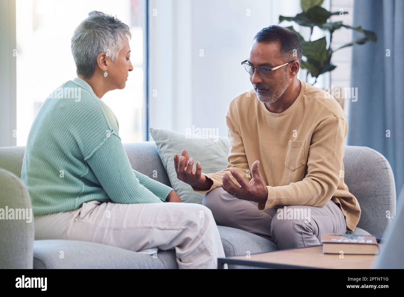 Couple, talking and conversation during fight on sofa about marriage problems, conflict and communication. Divorce, argument and frustrated relationsh Stock Photo