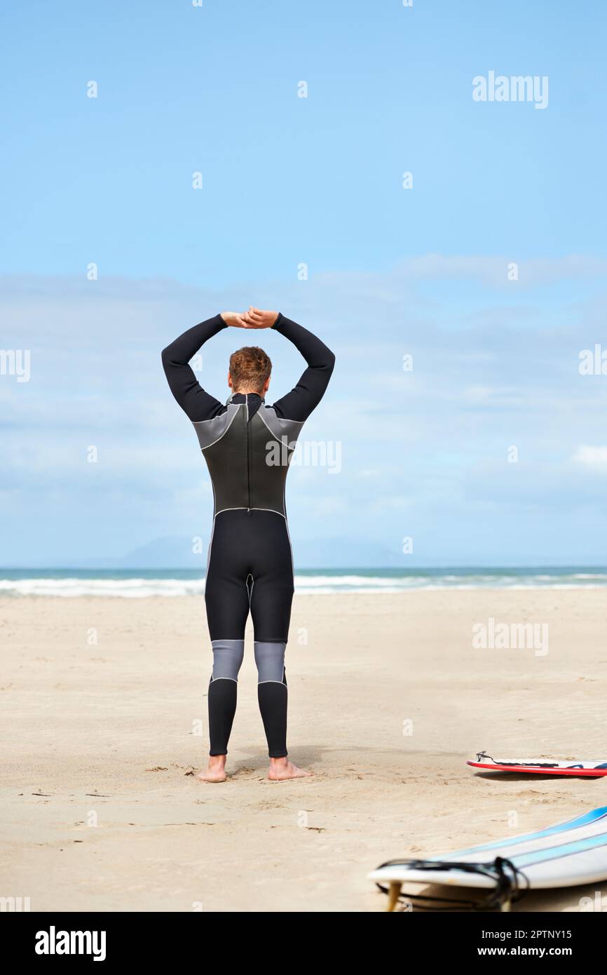 Getting ready to head into the waves. A surfer putting on his wetsuit