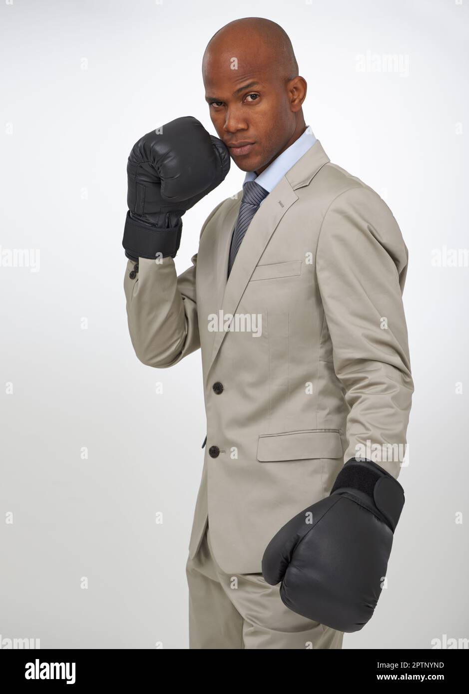 Ready for the corporate fight. Portrait of a handsome african businessman wearing boxing gloves Stock Photo